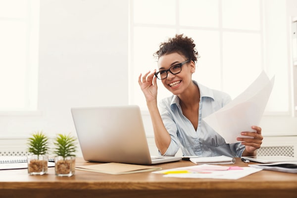 woman smiling and working at her desk