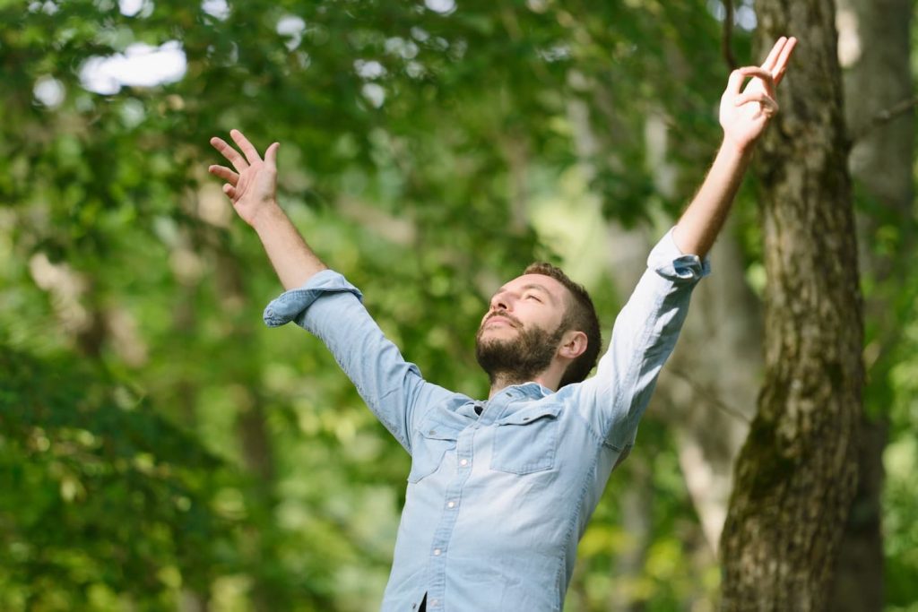 man with both arms raised